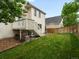 Landscaped backyard with grass, wooden deck with stairs, and privacy fence at 4436 Windmill Dr, Brighton, CO 80601