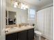 Well-lit bathroom features a double sink vanity, tiled countertop, and a shower with a curtain at 4436 Windmill Dr, Brighton, CO 80601