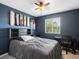 Modern bedroom with a blue accent wall, skateboard decor, and desk at 4436 Windmill Dr, Brighton, CO 80601