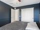 Bedroom with blue accent wall, striped bedding, and white closet doors at 4436 Windmill Dr, Brighton, CO 80601