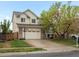 Inviting two-story home featuring a well-kept lawn, brick accents, and convenient two-car garage at 4436 Windmill Dr, Brighton, CO 80601