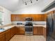 Well-equipped kitchen featuring stainless steel appliances, tile flooring, and wooden cabinets for storage at 4436 Windmill Dr, Brighton, CO 80601