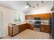 Efficient kitchen with stainless steel appliances, tiled floors, and bright, natural light at 4436 Windmill Dr, Brighton, CO 80601