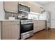 Modern kitchen with stainless steel appliances, light wood cabinets and gray backsplash, creating a sleek cooking space at 1711 Hooker St # 2, Denver, CO 80204
