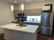 Modern kitchen featuring a stainless steel refrigerator, island with sink, and sleek countertops at 1711 Hooker St # 2, Denver, CO 80204