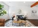 Cozy living room featuring a black leather sofa, round coffee tables, and rustic wood beam at 1711 Hooker St # 2, Denver, CO 80204