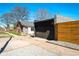 View of large detached garage with a wide driveway and wooden fence at 3105 N Elizabeth St, Denver, CO 80205