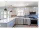 Spacious kitchen features shaker cabinets, stainless appliances, and a large island with a sink and view at 3105 N Elizabeth St, Denver, CO 80205