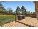 Spacious backyard deck features multiple grills, green grass and a privacy fence at 1604 Brookside Dr, Highlands Ranch, CO 80126
