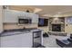 Basement wet bar with granite counters, mini fridge, and stacked stone fireplace at 1604 Brookside Dr, Highlands Ranch, CO 80126