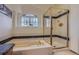 Bright bathroom with bathtub and separate glass shower with gold trim and window at 1604 Brookside Dr, Highlands Ranch, CO 80126