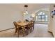 Open-concept dining area with a view of the living room, with vaulted ceiling and big windows at 1604 Brookside Dr, Highlands Ranch, CO 80126
