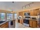 Bright eat-in kitchen with granite counters, stainless appliances, and wood cabinets at 1604 Brookside Dr, Highlands Ranch, CO 80126