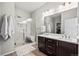 This bathroom features dual sinks, dark cabinets, and a tiled glass shower with a built-in bench at 401 Clubhouse Dr, Fort Lupton, CO 80621