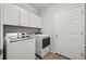 Efficient laundry room equipped with white cabinets and modern washer and dryer units at 401 Clubhouse Dr, Fort Lupton, CO 80621