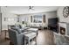 Open-concept living room with hardwood floors, a fireplace, comfortable seating, and large windows at 401 Clubhouse Dr, Fort Lupton, CO 80621
