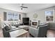 Bright living room features a fireplace, large window, ceiling fan, and comfortable seating arrangement at 401 Clubhouse Dr, Fort Lupton, CO 80621