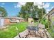 Large backyard with a patio seating area, mature trees, and plenty of room for entertaining at 9150 Fir Dr, Thornton, CO 80229