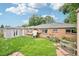 Well-maintained backyard featuring a lush lawn, brick house, and a cozy garden area at 9150 Fir Dr, Thornton, CO 80229