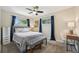 Charming bedroom with a ceiling fan, grey bed, blue curtains, and lots of light at 9150 Fir Dr, Thornton, CO 80229