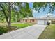 A charming brick home with a well-manicured lawn and long concrete driveway at 9150 Fir Dr, Thornton, CO 80229