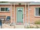 A charming brick home with a green front door and decorative welcome mat at 9150 Fir Dr, Thornton, CO 80229