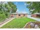 Charming brick home with a well-manicured lawn, walkway, and green front door at 9150 Fir Dr, Thornton, CO 80229