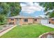 Charming brick home with a well-manicured lawn, walkway, and green front door at 9150 Fir Dr, Thornton, CO 80229