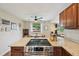 The granite countertop kitchen has stainless appliances, wood cabinets, and transitions into dining space at 9150 Fir Dr, Thornton, CO 80229