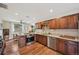 Modern kitchen with stainless steel appliances, wood cabinets, and dining area at 9150 Fir Dr, Thornton, CO 80229