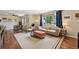 Open-concept living room with modern furnishings, dining area, and natural light at 9150 Fir Dr, Thornton, CO 80229