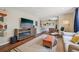 Bright living room with modern furnishings, stylish rug, and a TV with fireplace console at 9150 Fir Dr, Thornton, CO 80229