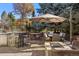 Inviting patio with outdoor kitchen, dining set, fire pit, and lush greenery, perfect for relaxing and entertaining at 2 Fieldstone Trl, Englewood, CO 80113