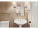 Elegant bathroom featuring a pedestal sink, decorative mirror, and sconce lighting at 2 Fieldstone Trl, Englewood, CO 80113