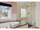 Bathroom featuring soaking tub, separate glass shower, and large window with scenic view at 2 Fieldstone Trl, Englewood, CO 80113