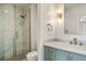 Modern bathroom featuring glass-enclosed shower with stone flooring and blue vanity at 2 Fieldstone Trl, Englewood, CO 80113