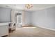 Bright bedroom featuring large window, modern light fixture, and neutral carpet at 2 Fieldstone Trl, Englewood, CO 80113