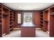 Custom walk-in closet with window, storage shelves and a large center island at 2 Fieldstone Trl, Englewood, CO 80113