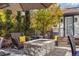 Inviting stone firepit with comfortable seating on a stone patio surrounded by lush landscaping at 2 Fieldstone Trl, Englewood, CO 80113