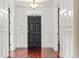 Grand foyer featuring wainscoting, hardwood floors, and striking black front door at 2 Fieldstone Trl, Englewood, CO 80113