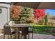 Outdoor kitchen with bar-style seating, grill and verdant landscape, ideal for outdoor entertaining and dining at 2 Fieldstone Trl, Englewood, CO 80113