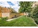 Lush green backyard with brick wall, a shady tree, and patio furniture at 85 N Ogden St # 34, Denver, CO 80218