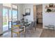 Modern dining area with glass table, stylish chairs, and sliding glass door to the outdoor patio at 864 Clover Loop, Erie, CO 80026