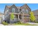 Charming two-story home featuring a covered front porch, well-maintained lawn and two-car garage at 864 Clover Loop, Erie, CO 80026