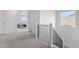 Hallway has neutral carpet, white walls and black bannister at 864 Clover Loop, Erie, CO 80026