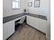 Bright home office with custom desk, white cabinets, and hardwood floors at 864 Clover Loop, Erie, CO 80026