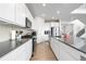 Bright kitchen features white cabinets, stainless steel appliances, and light hardwood floors at 864 Clover Loop, Erie, CO 80026