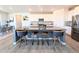 Modern kitchen boasts sleek white cabinets, stainless steel appliances, and a spacious center island with seating at 864 Clover Loop, Erie, CO 80026