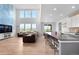 Open concept kitchen and living space boasts high ceilings, large windows, and modern finishes at 864 Clover Loop, Erie, CO 80026