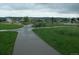 A wide paved walking trail winds through a community park with trees, grass, and park features at 877 Eldorado Dr, Superior, CO 80027